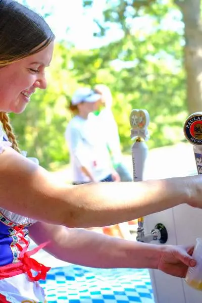 German woman pouring a beer from a tap