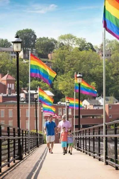 People walking down the bridge with flags along it