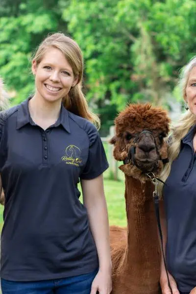 Two Woman holding to alpacas